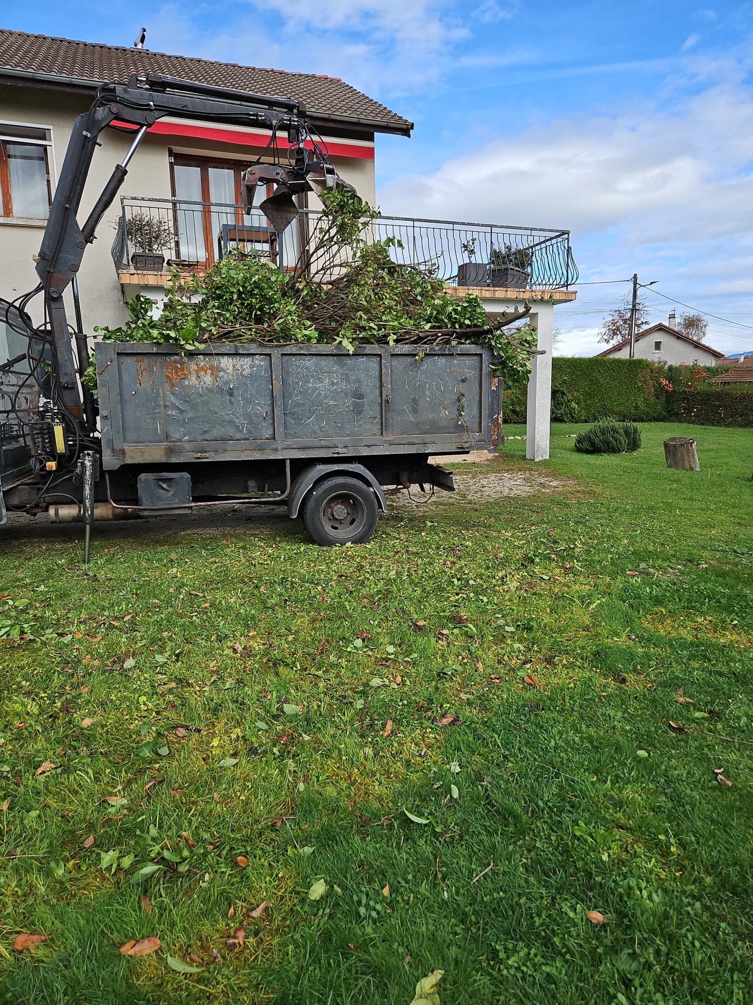 Camion-grue Isère Débarras chargeant des branches